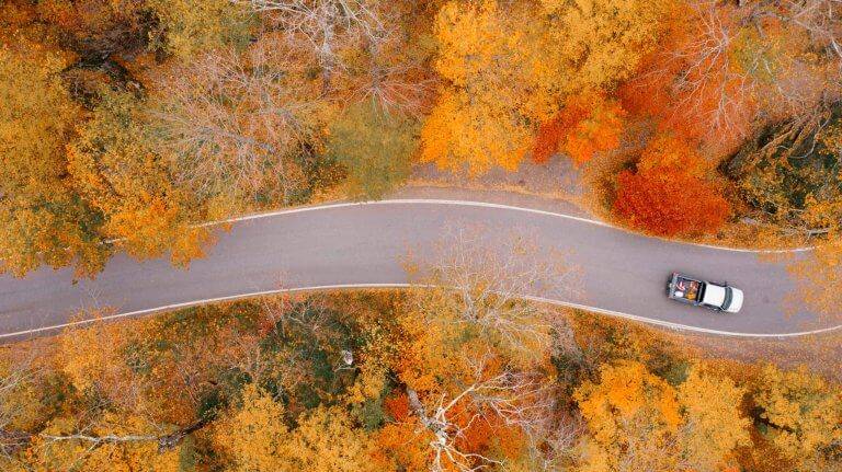 Driving on a winding road through fall-colored trees near Coeur d'Alene