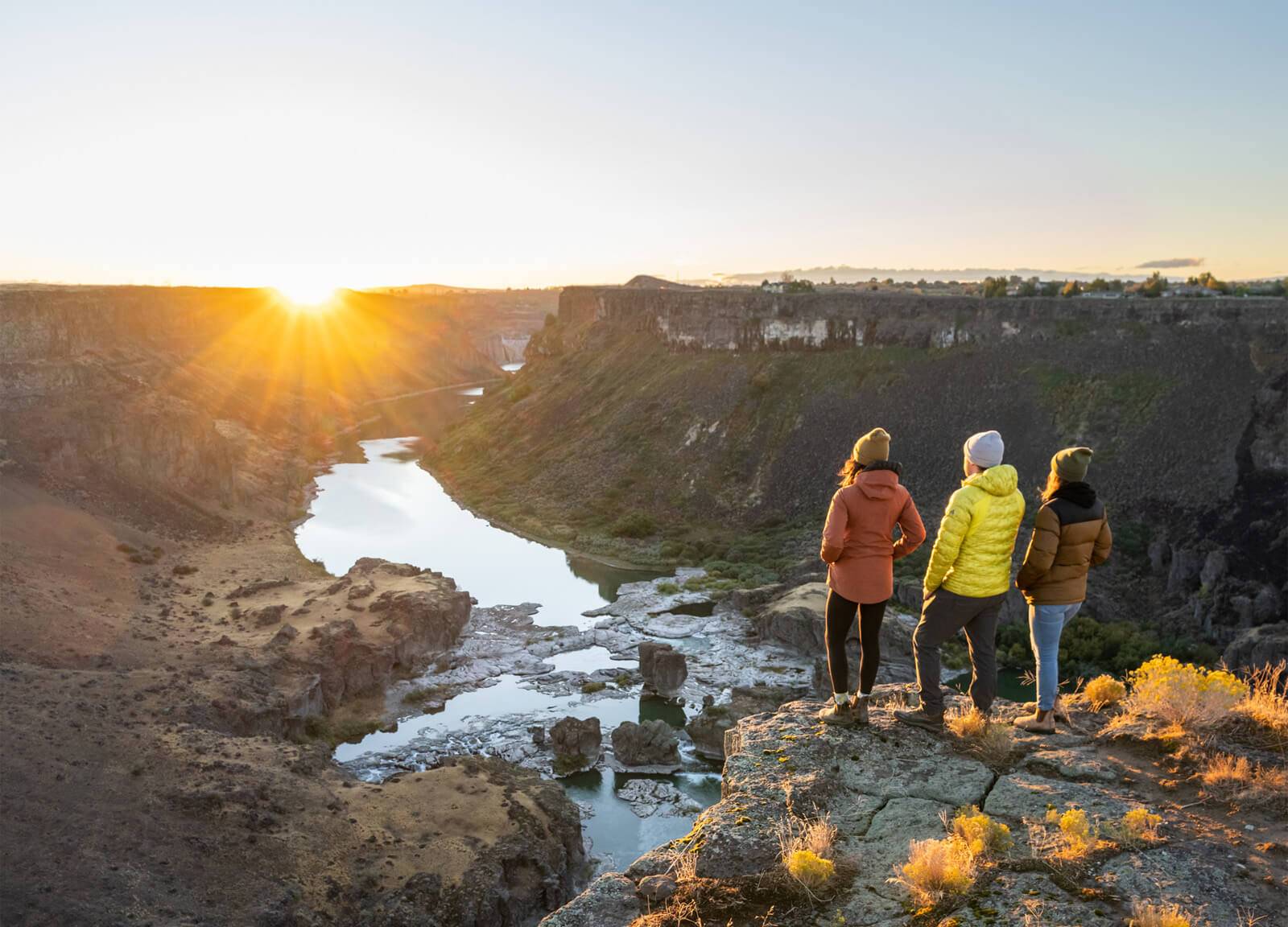 Three people look at Pillar Falls in the Snake River Canyon.