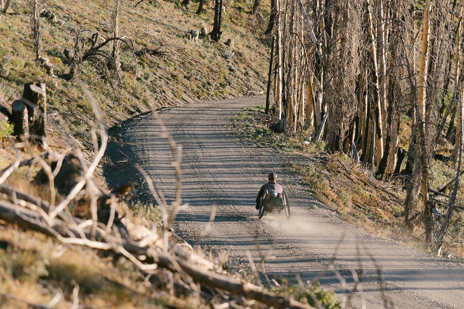 Andre Kajlich cycling along a dirt road.