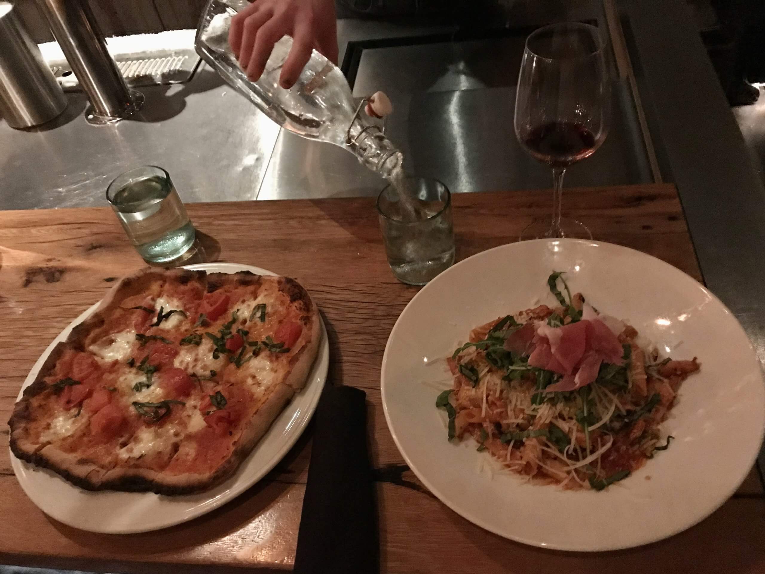 pizza and pasta plated on a table.