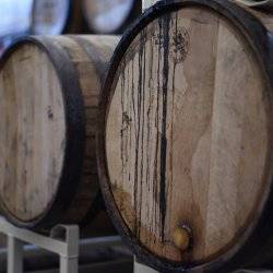 Up-close view of three distillery barrels laying on their sides.