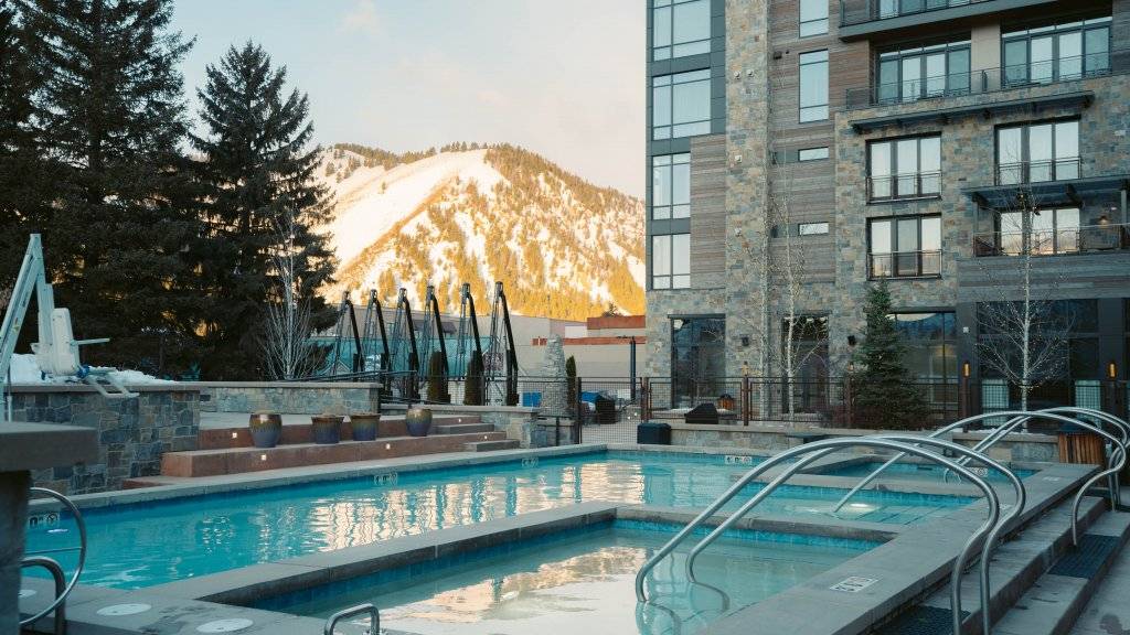 exterior of limelight hotel with view of snowy mountain and pool