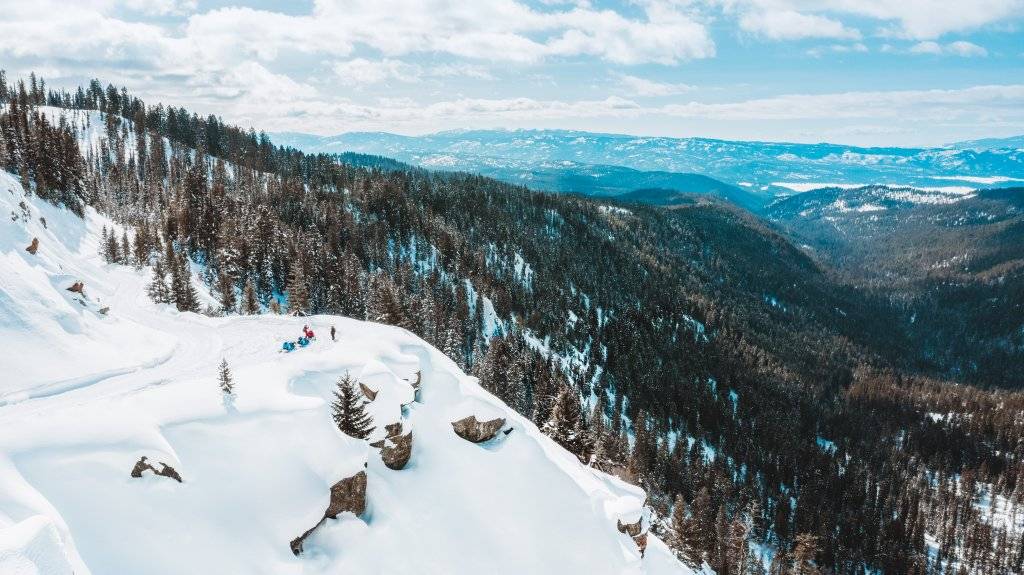 aerial view of people on snowmobiles at mountain overlook