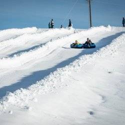 people in tube going down snowy tubing hill