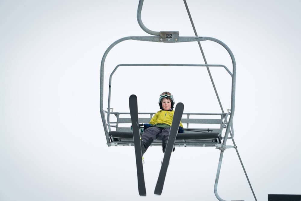 child sitting on ski lift