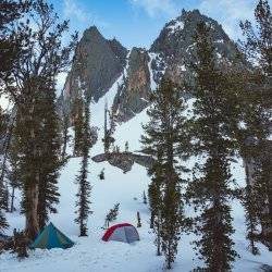 two small tents against snowy mountains