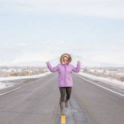 woman in snow gear on snowy road