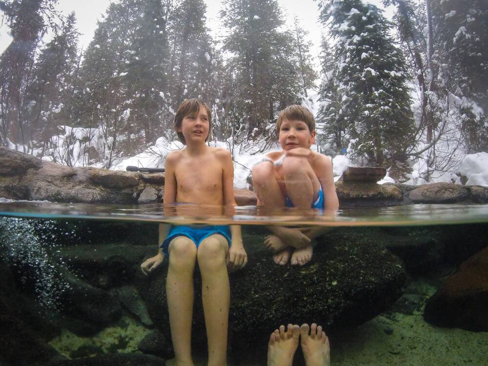 family sitting in hot spring hot pool