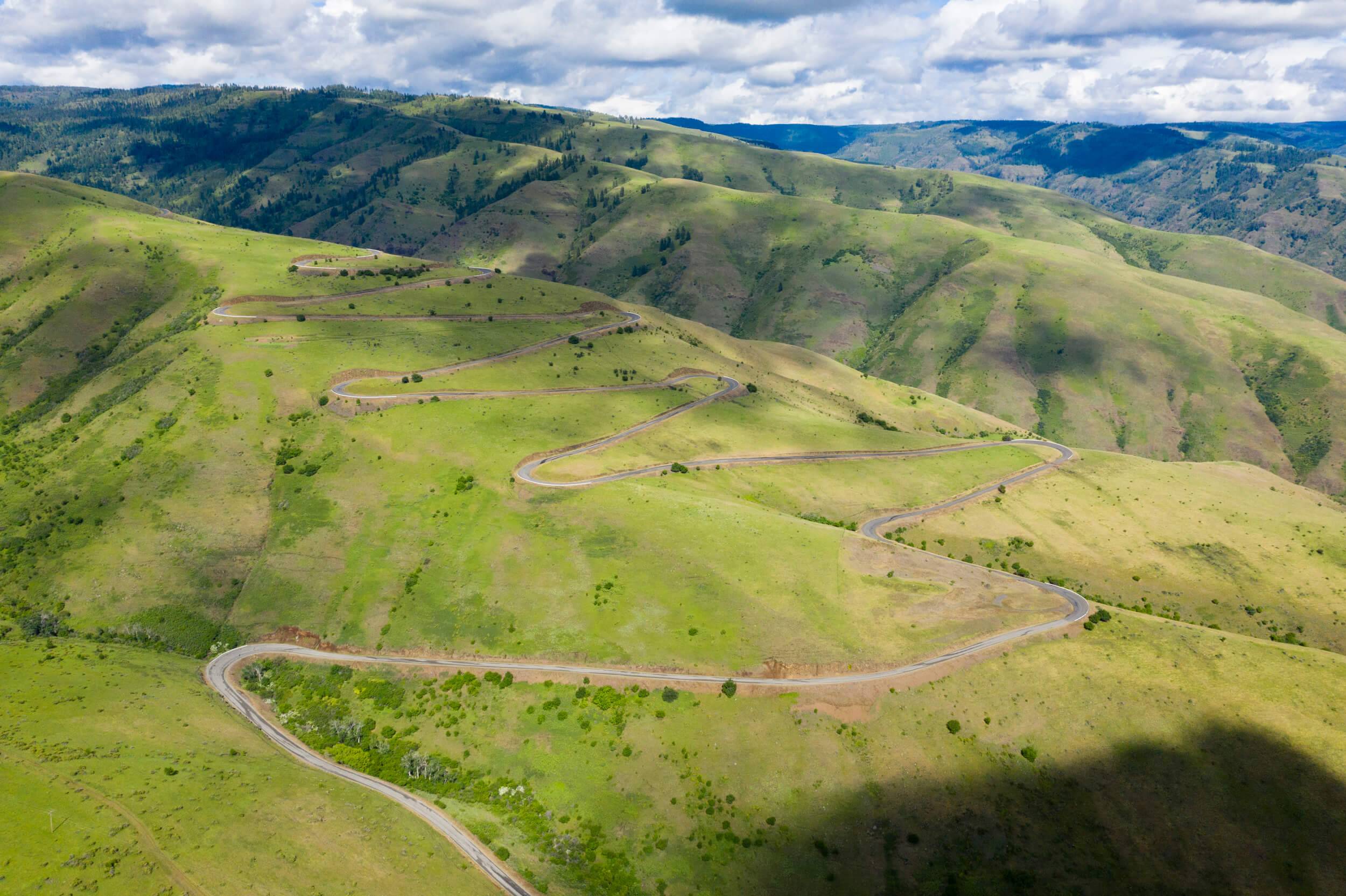 aerial view of hills and a road with clouds casting shadows