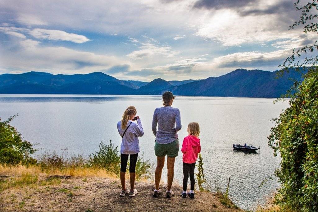 mom and daughters looking at a lake 