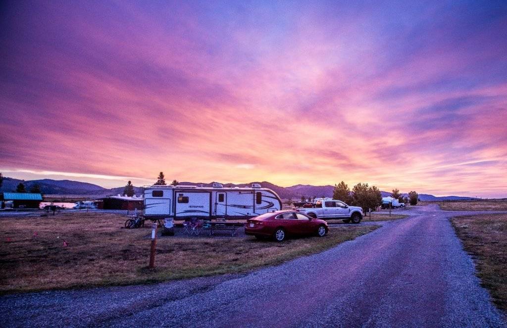 sunset with travel trail and truck in foreground