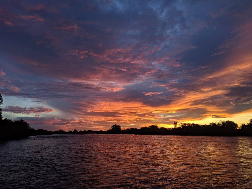 orange, pink and blue sunset over river