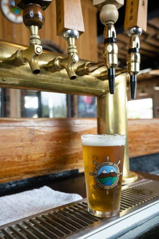 beer in pint glass sitting under beer tap