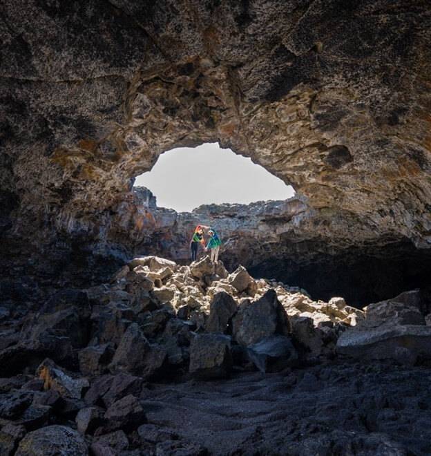 people inside tunnel at craters of the moon