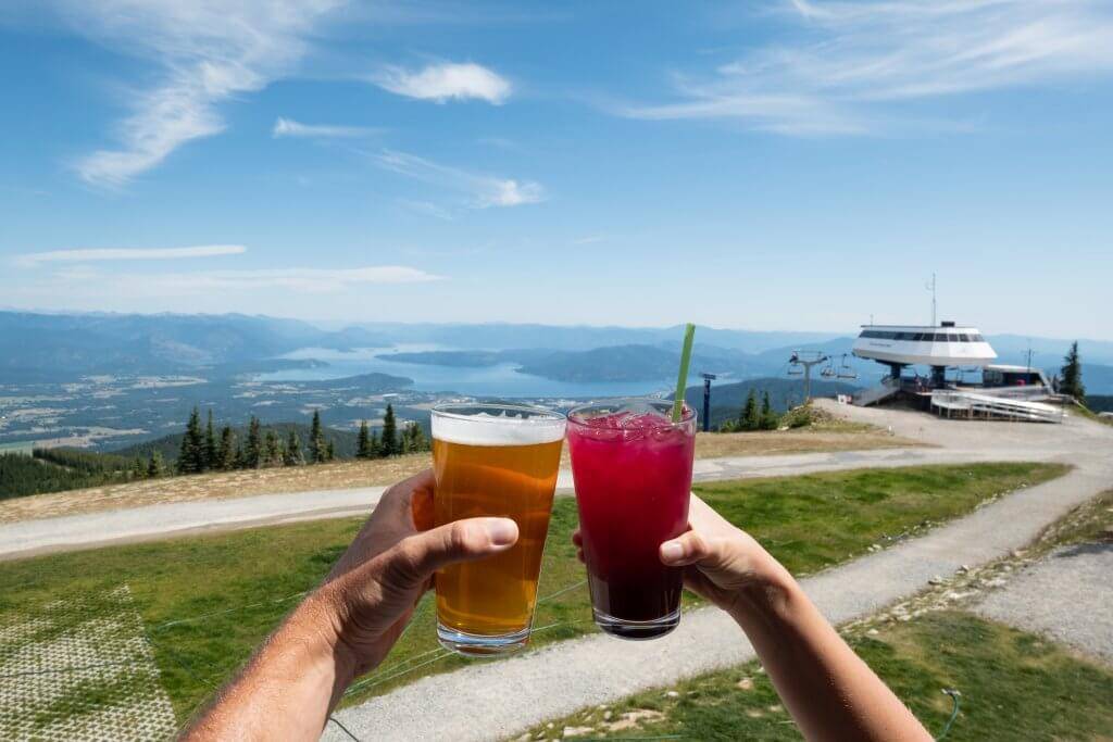 people holding cocktails with a lake in the background