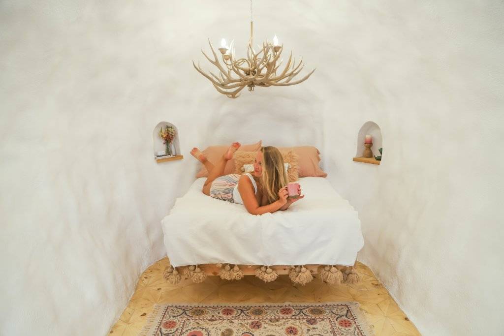 woman laying on bed inside Potato Hotel