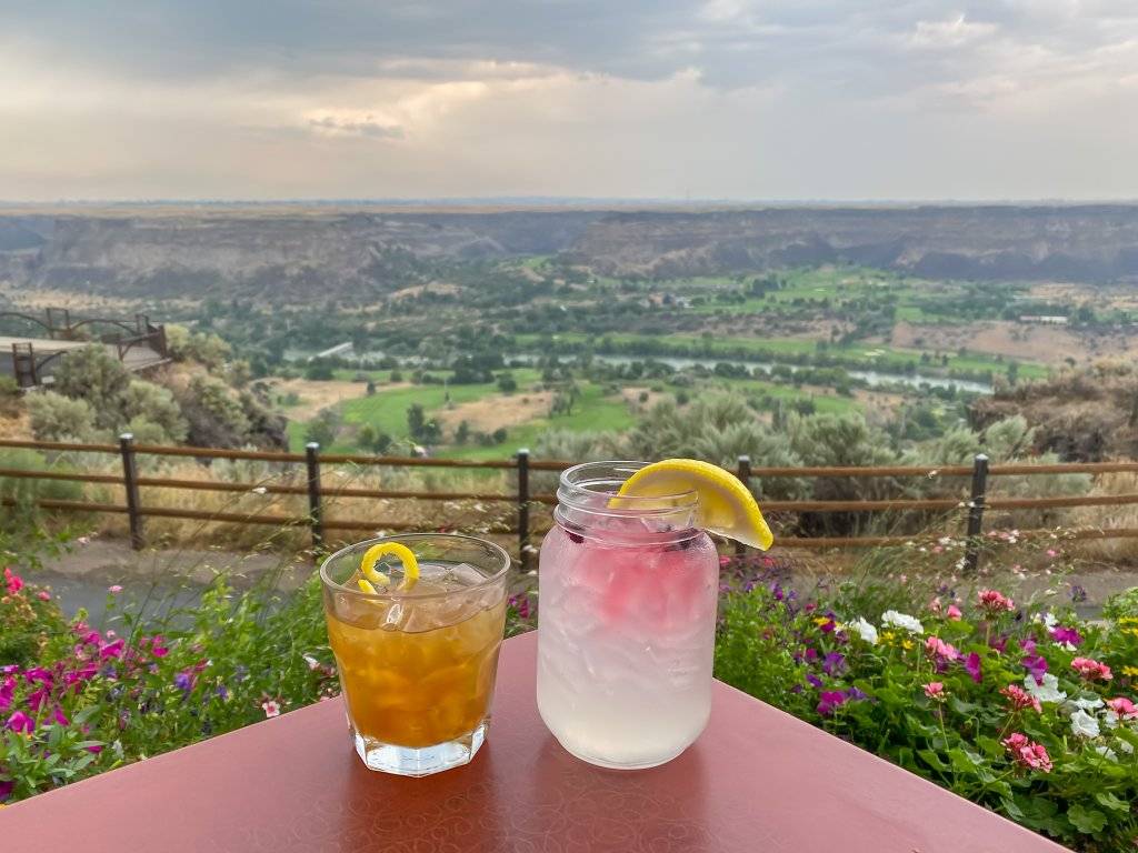 two cocktails on table overlooking snake river canyon