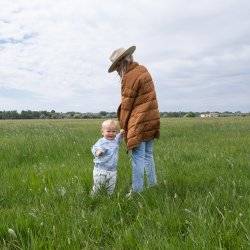 mom walking with small child in tall grass