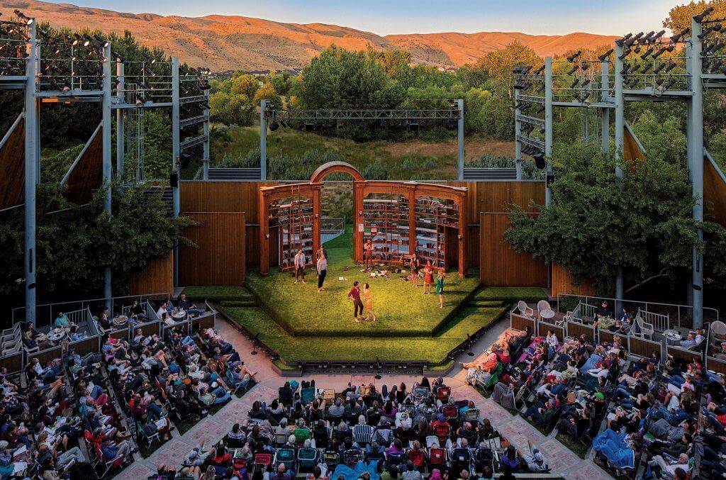 a crowd of people watching a performance at an outdoor amphitheater