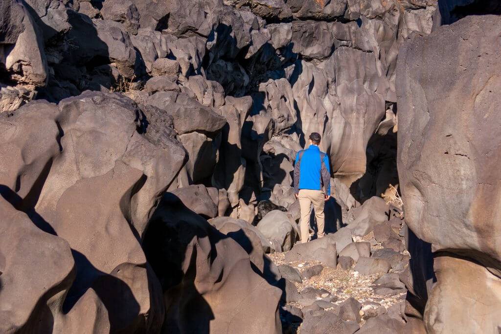 people walking through large rock field