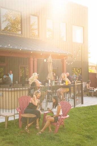 two women in chairs on lawn of winery