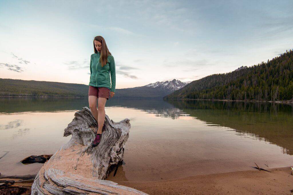 woman standing on log looking at water at Redfish Lake