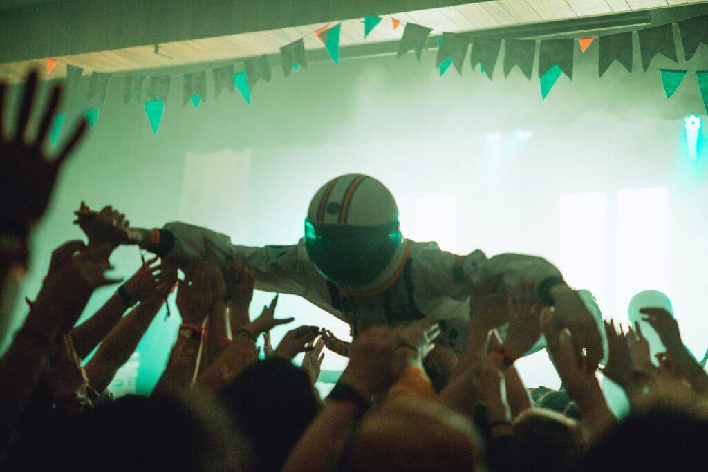 person dressed as astronaut crowd surfing