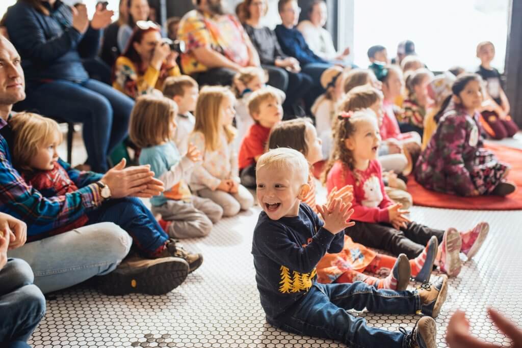 kids sitting on floor clapping hands