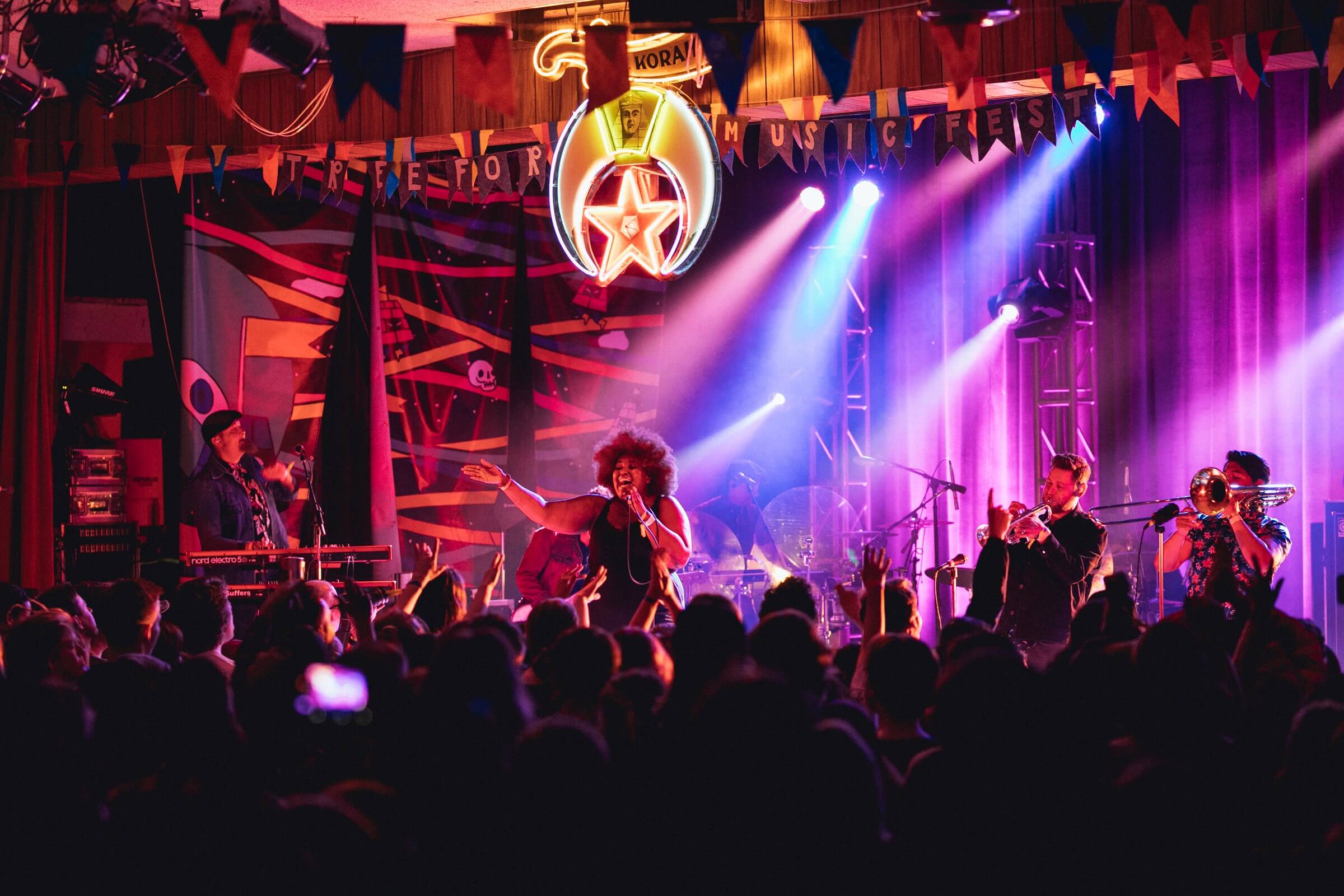 woman on stage singing to a crowd