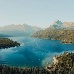 A view of the sweeping pine tree forest and mountain peaks surrounding Redfish Lake.