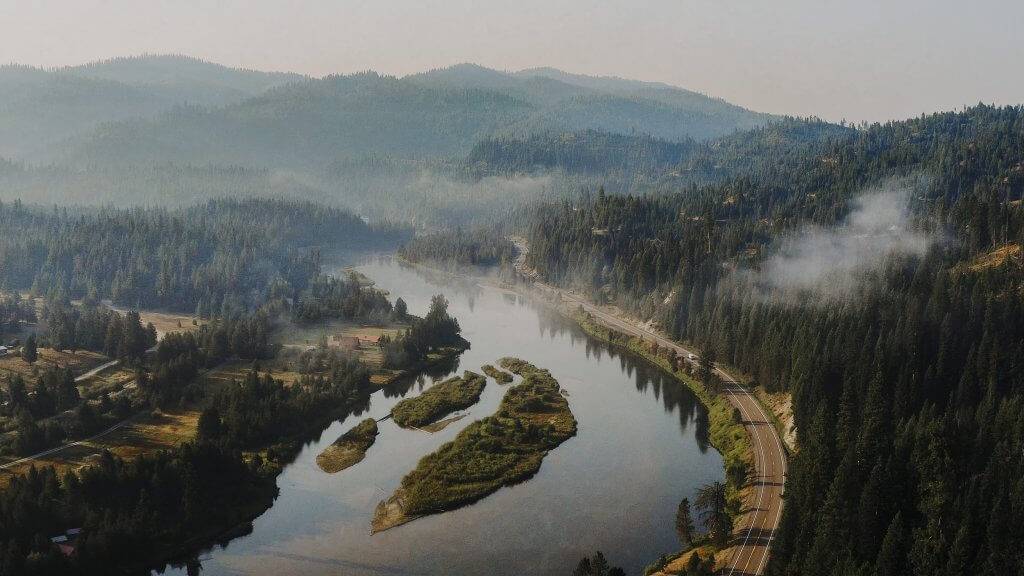 A top view of the Payette River running along the Payette River Scenic Byway, surrounded by trees.