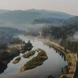 A top view of the Payette River running along the Payette River Scenic Byway, surrounded by trees.