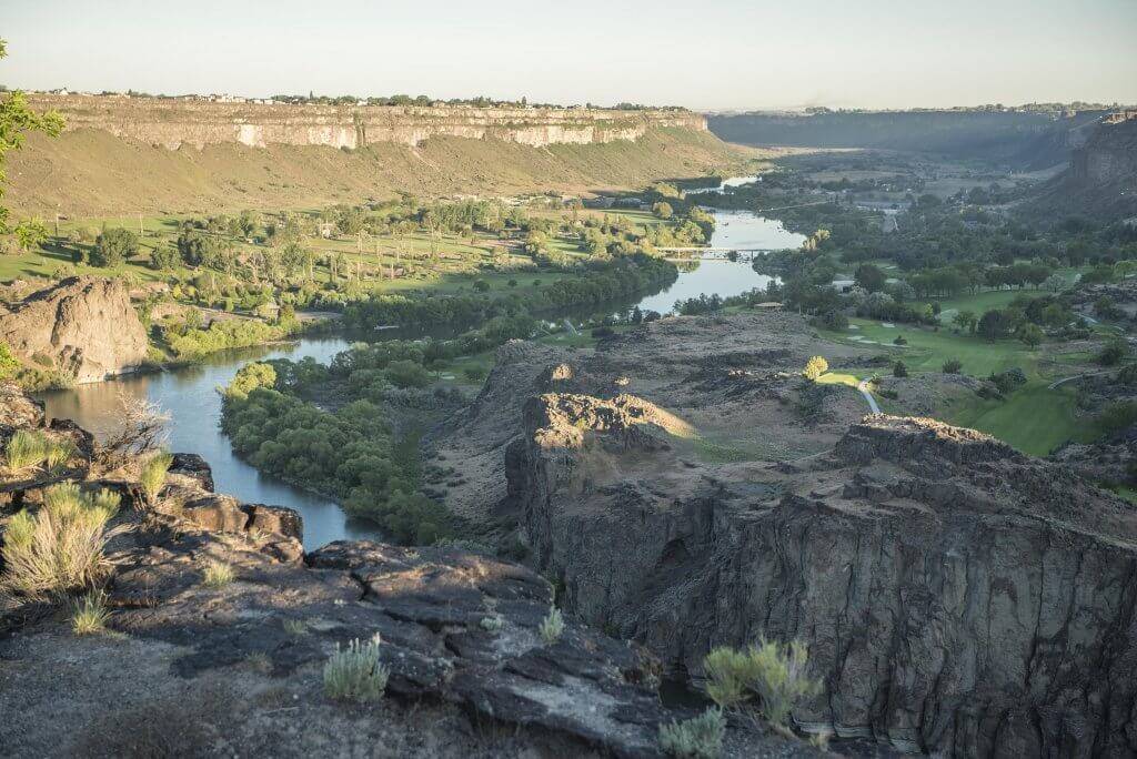 An overhead view of the Snake River running through a tree covered canyon.