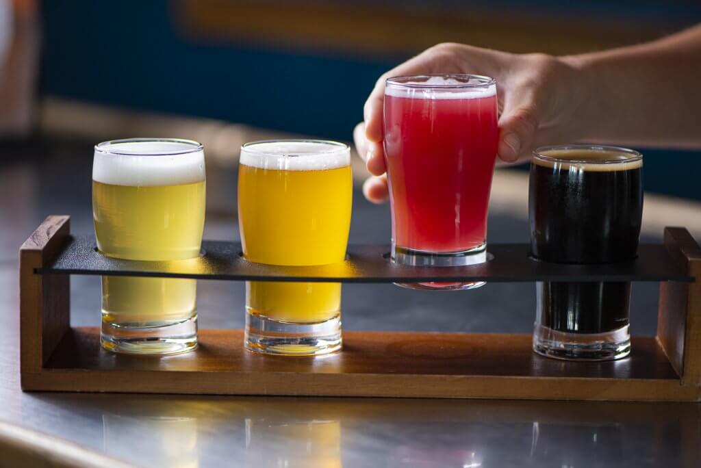 A person picks up a glass of beer at Grand Teton Brewing