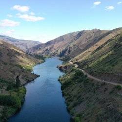 An overview of a road alongside a river running through a canyon.