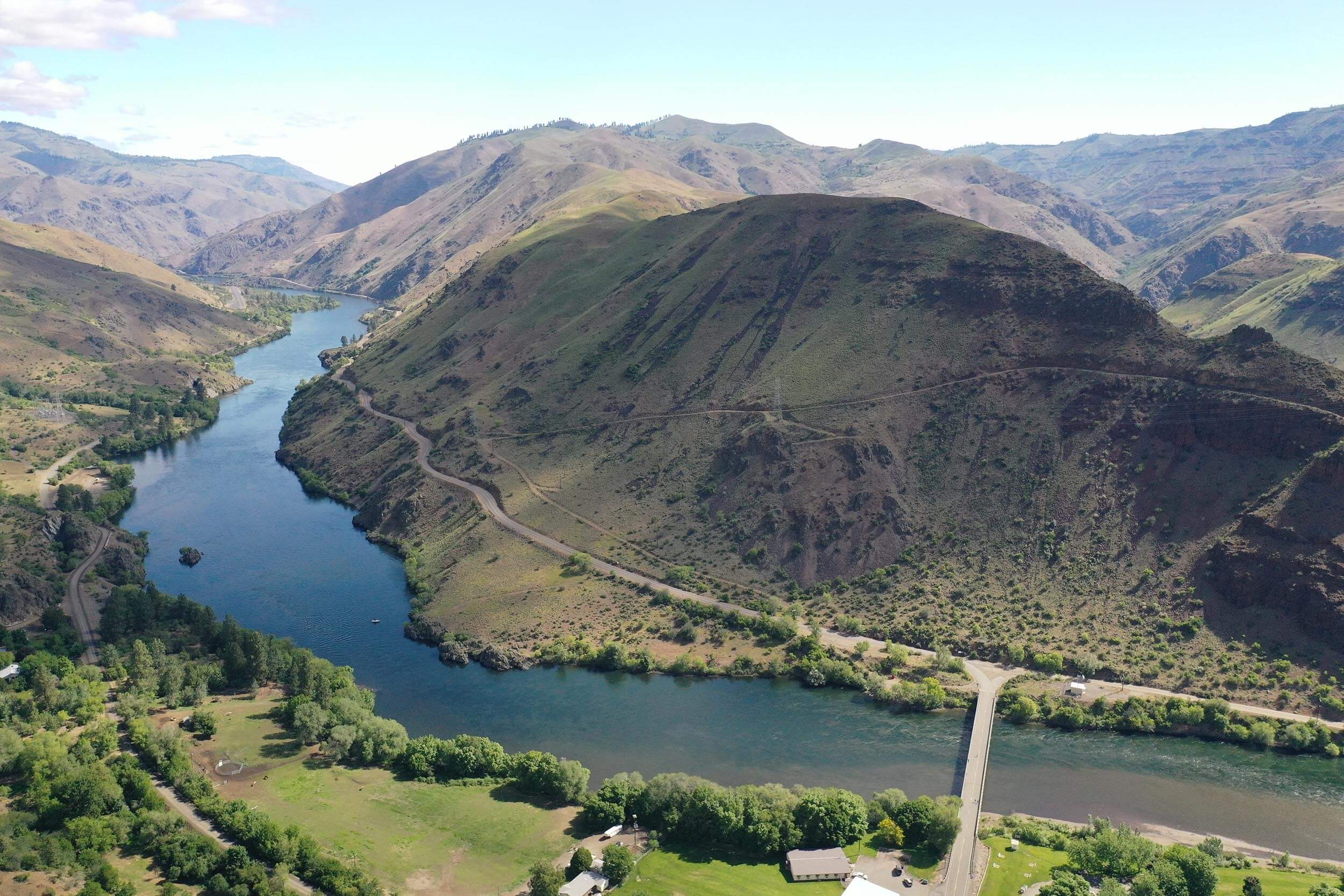 an overhead view of a river running through a canyon with mountains in the background