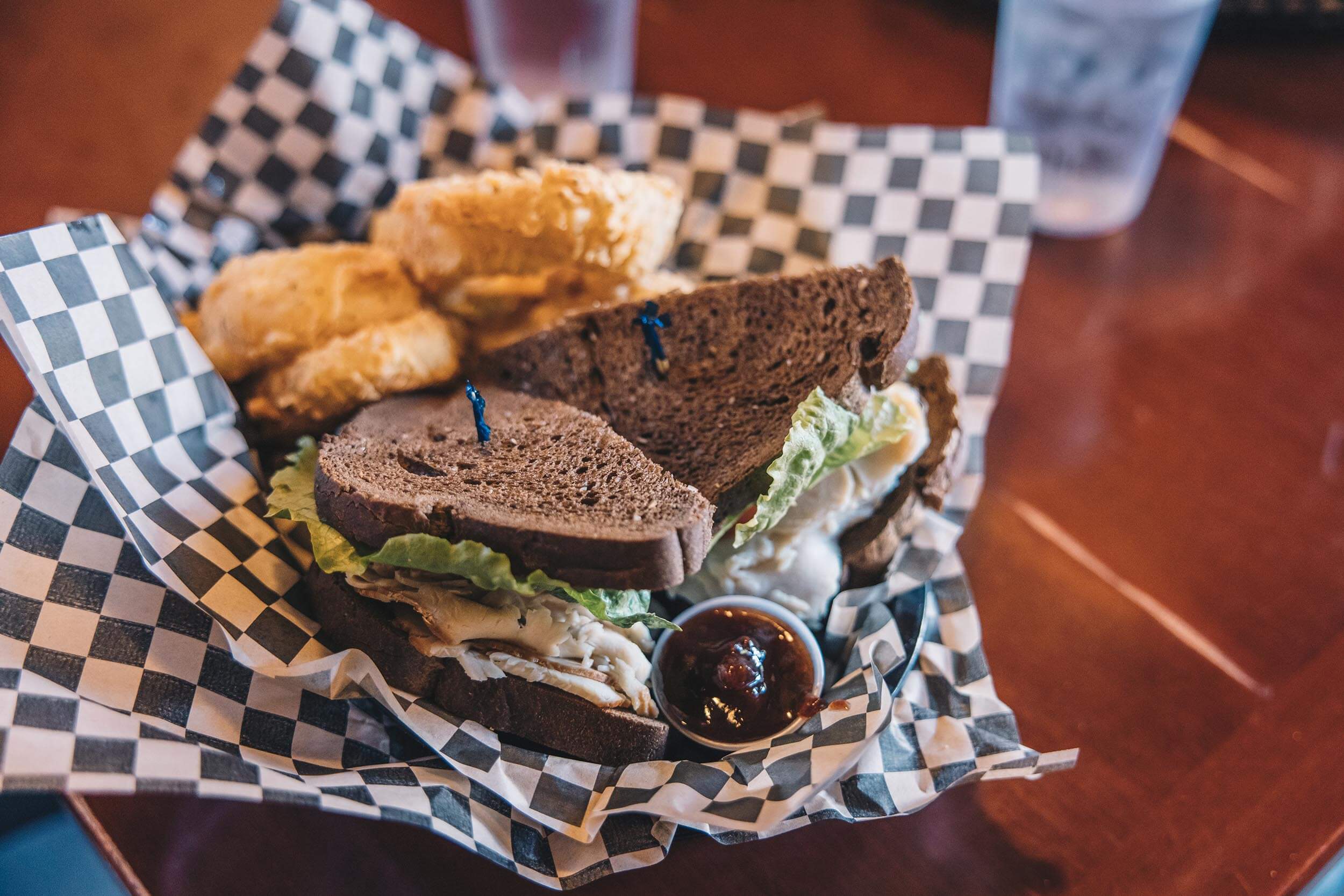 closeup of a sandwich and onion rings on a table