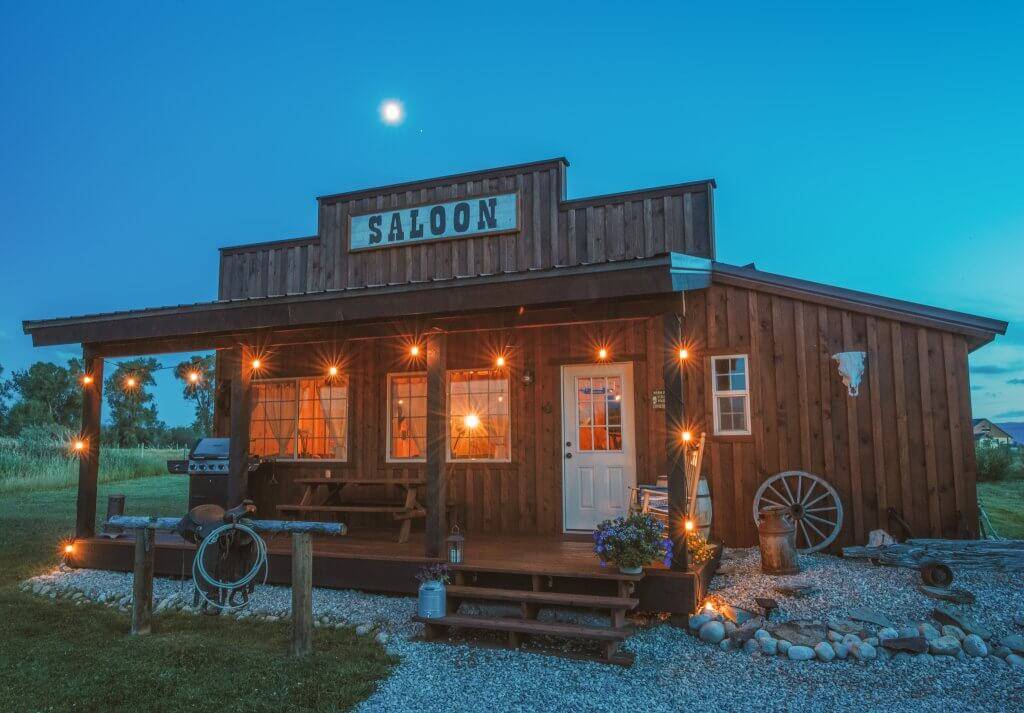 The exterior shines glowing lights outside the Western Saloon in Tetonia at night.