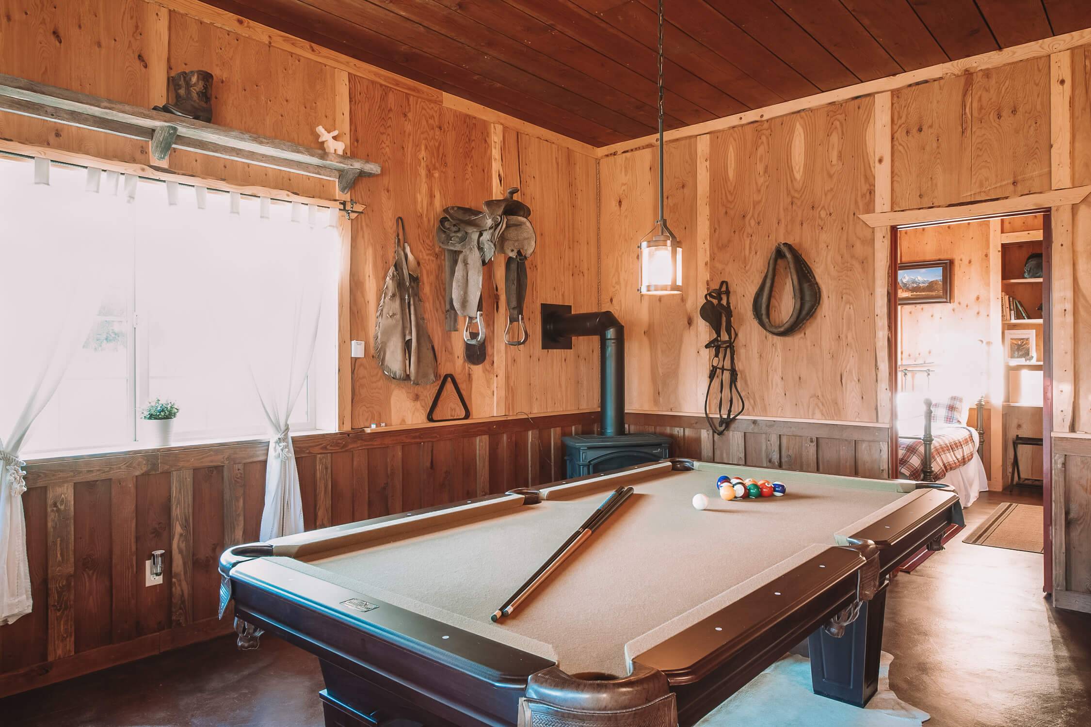 A pool cue and pool balls rest on the table as western decor lines the walls inside the Western Saloon in Tetonia.