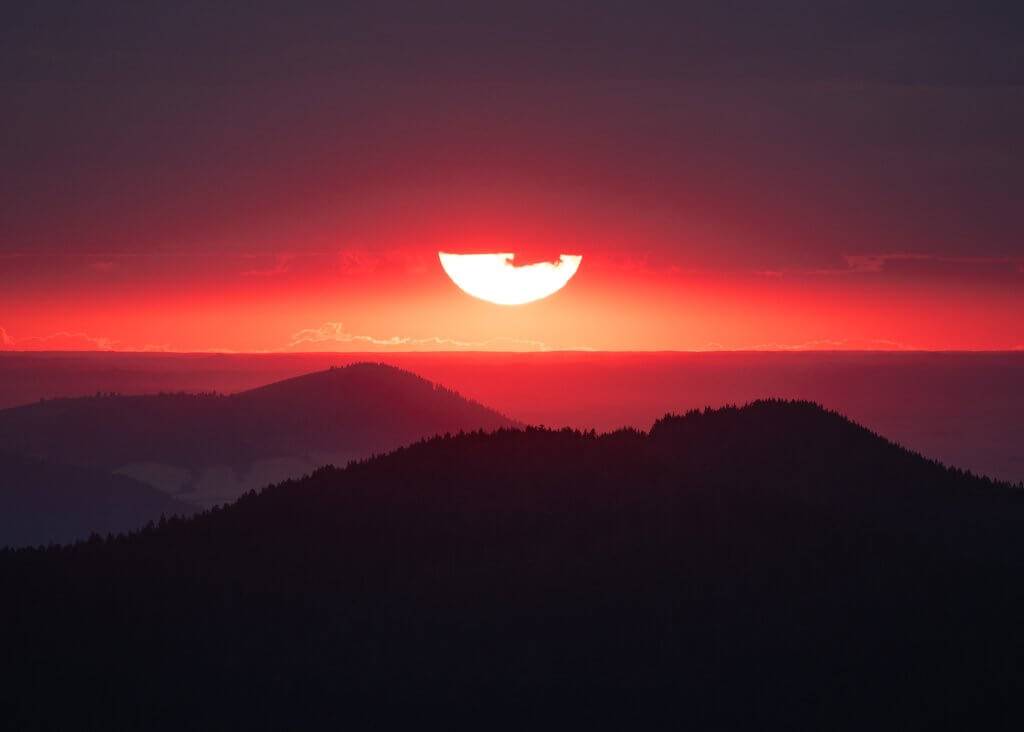 view of bright red and pink sunset over mountains from Bald Mountain Lookout