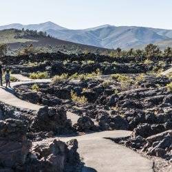 A father and a child walking along the Caves Trail at Craters of the Moon National Monument & Preserve.