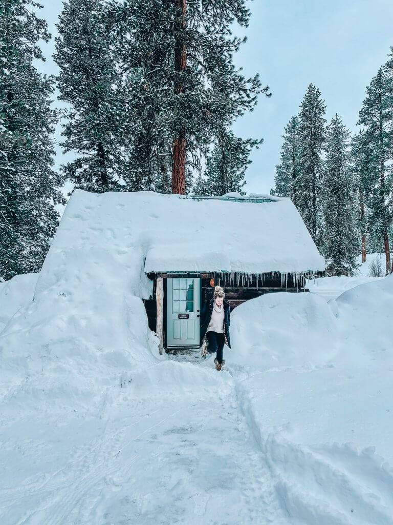 woman standing outside warm lake lodge