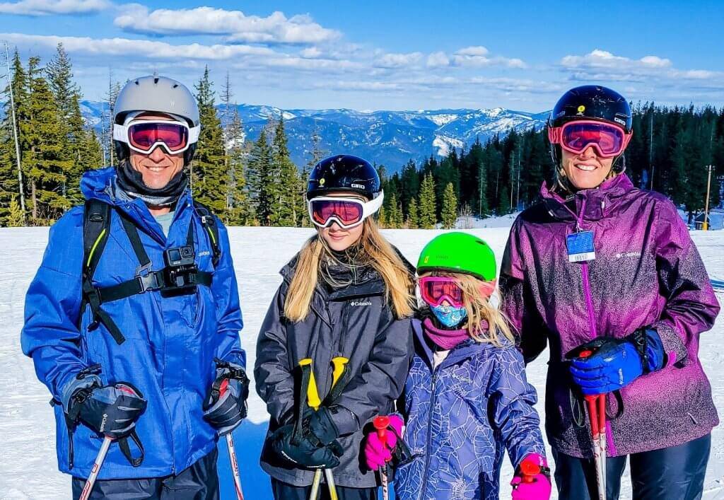 family of four in ski gear standing at silver mountain resort