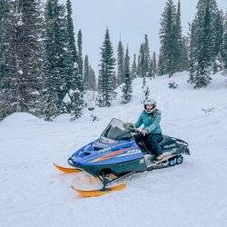 woman on snowmobile with snow in background