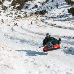 A man catches air while on a snow tube at the McCall Activity Barn.