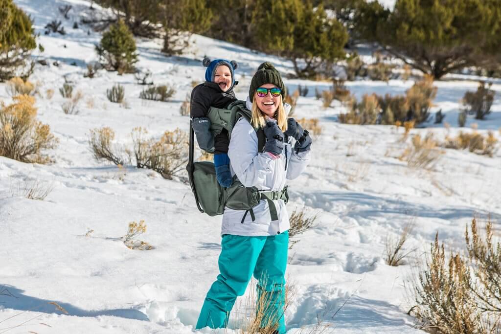 mom with baby in pack snowshoeing