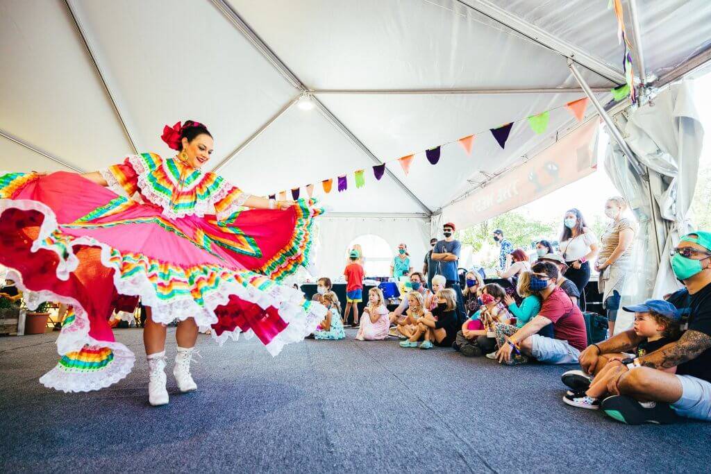 woman dancing with audience sitting on ground