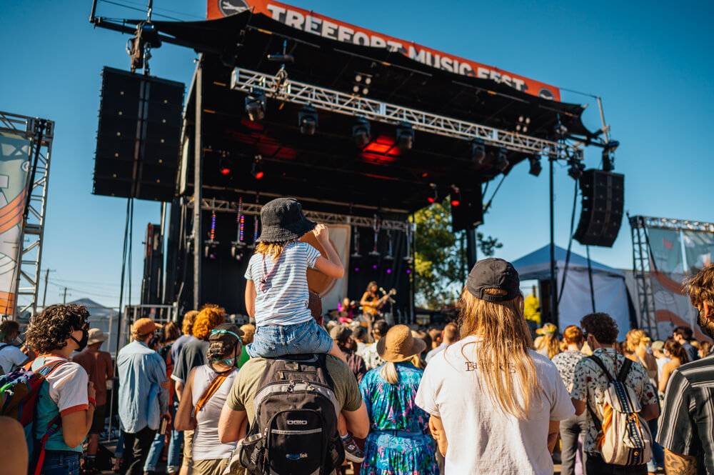 kdi sitting on adult's shoulders at Treefort main stage