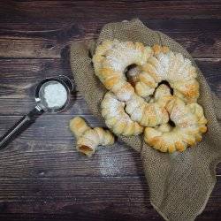 An overhead shot of rolls sprinkled with powder on a burlap cloth.