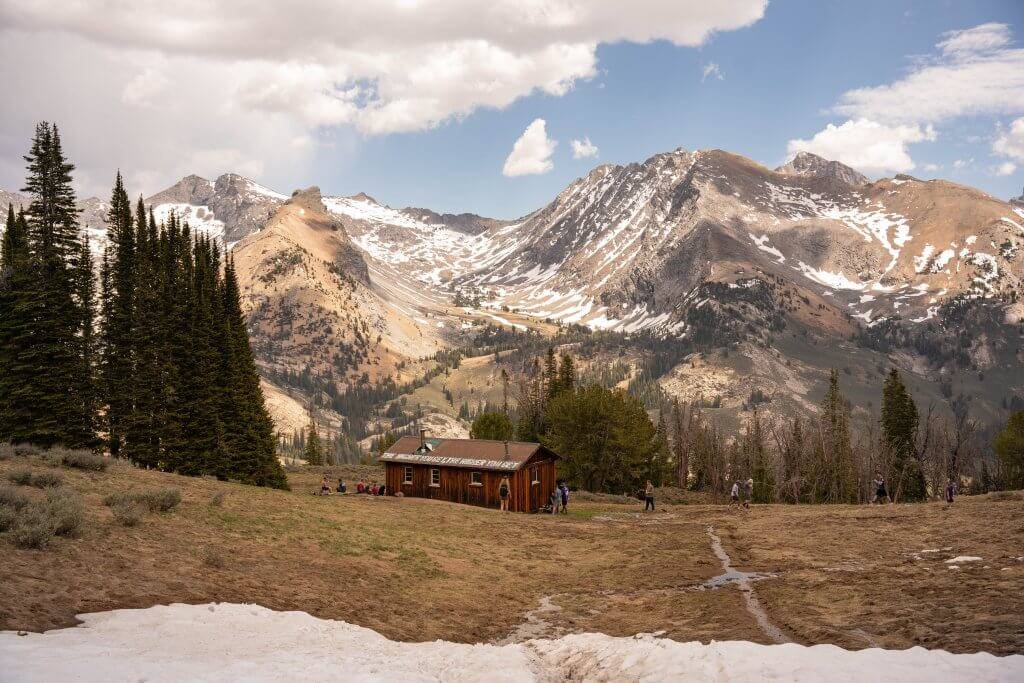 high mountain cabin with trail in foreground and mountains in background